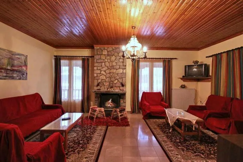 Σαλόνι με κόκκινους καναπέδες και ξύλινο ταβάνι